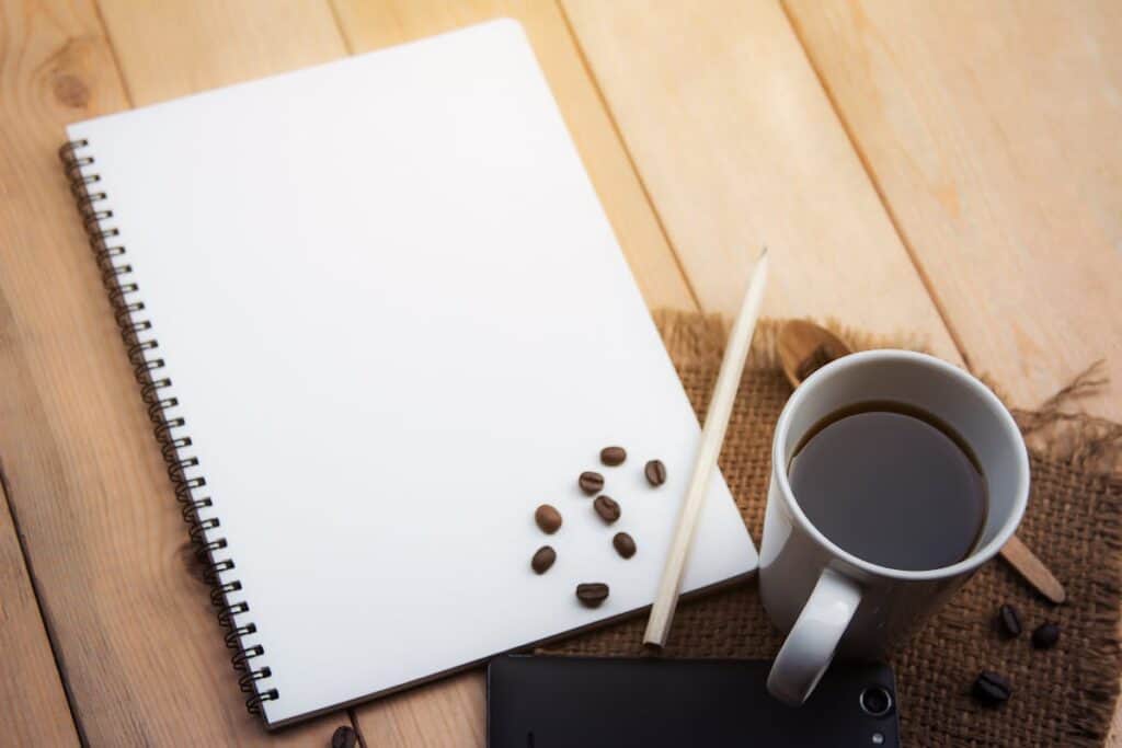 notebook and cup of coffee on a desk